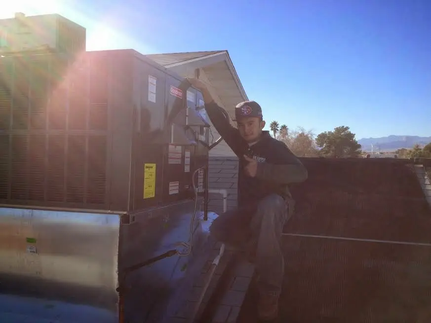 HVAC technician performing AC Tune-Up on a rooftop unit in Portsmouth